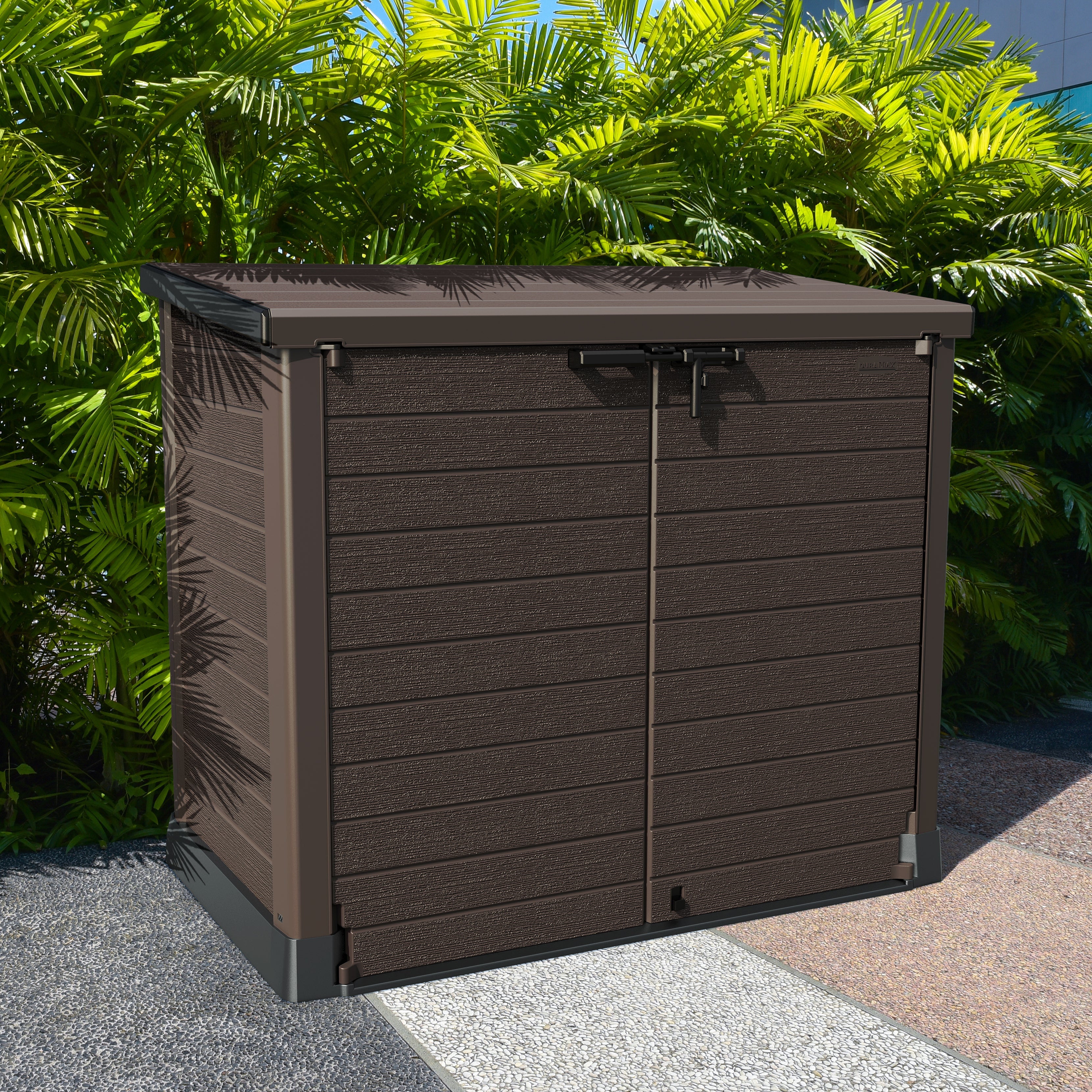 Duramax StoreAway 1200L Brown outdoor storage box with a green leafy background