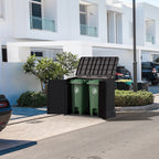 Duramax StoreAway Brown trash bin with green trash cans inside, placed on a driveway in front of a white building. Wheelie bin storage