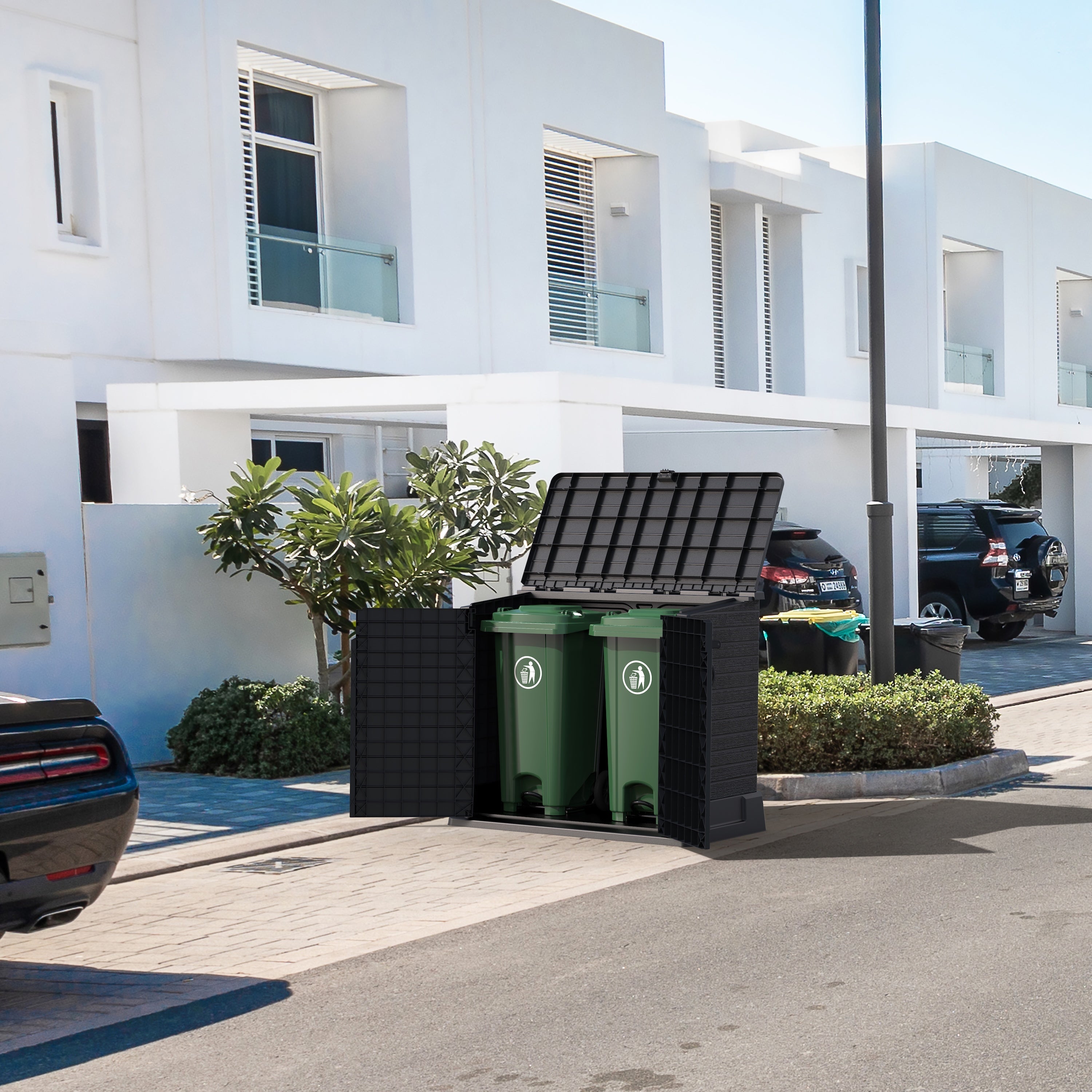Duramax StoreAway8 50L wheelie garbage box with green trash cans inside, placed outdoors near a building.