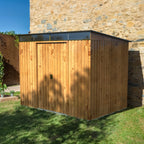 Duramax TOP Skylight 8x6 metal shed in wood imitation color with a metal roof with skylight against a stone wall.